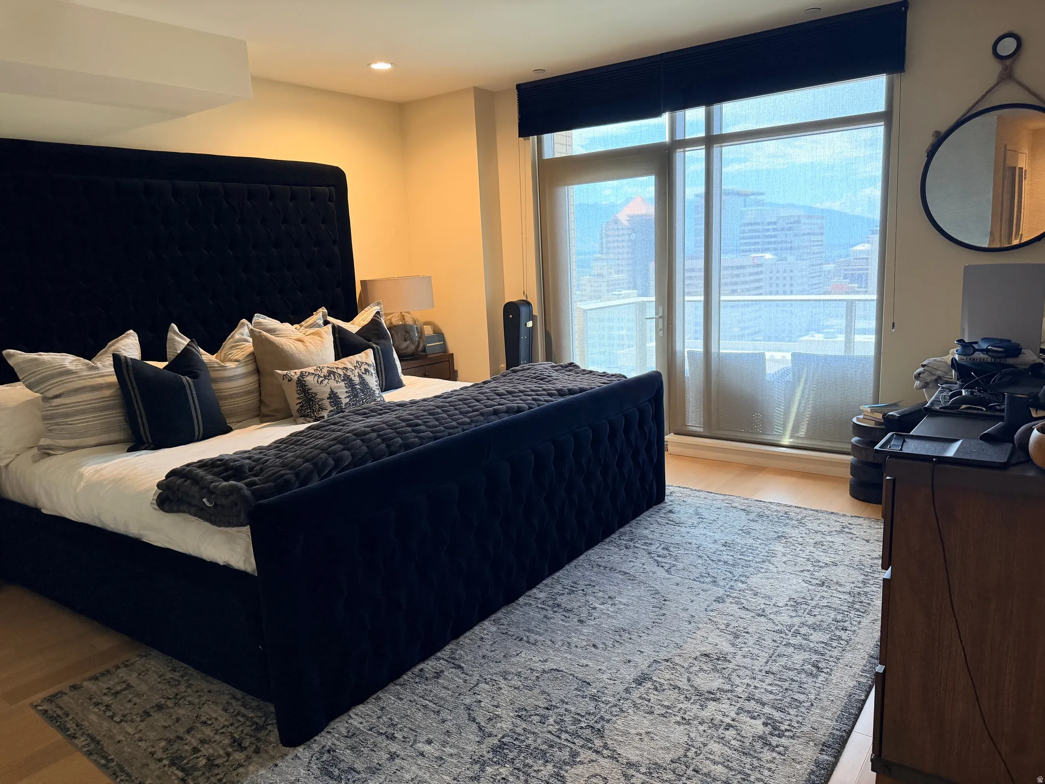 Luxurious primary bedroom showcasing a custom upholstered bed frame with tufted detailing, layered bedding with decorative pillows, and a quilted throw