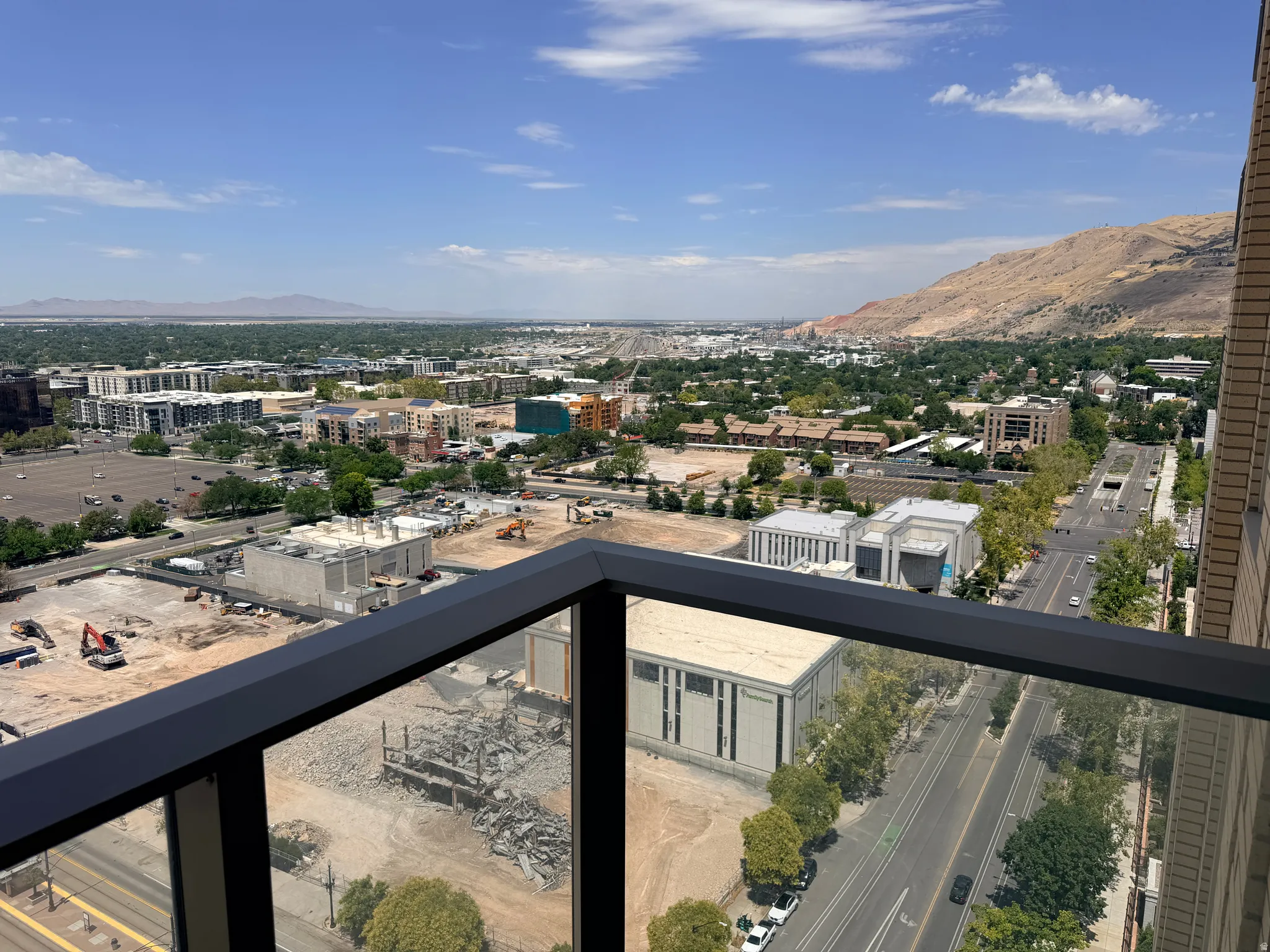 Expansive balcony with modern black metal railing offering panoramic vistas of the valley below