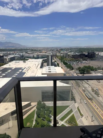 Expansive urban panorama from a high-level balcony with glass and dark metal railings
