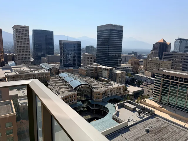 Expansive city skyline with distant mountains, featuring multiple high-rise buildings and modern architectural structures