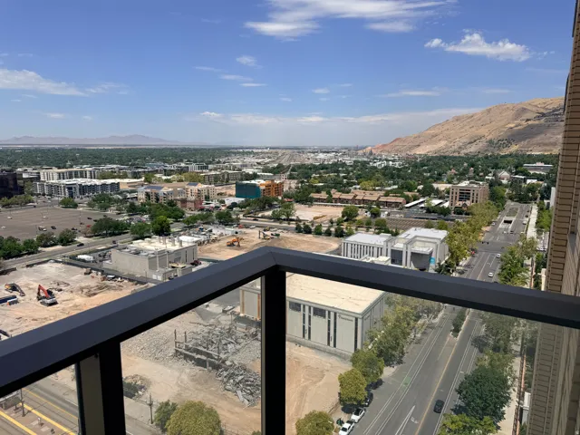Expansive balcony with modern black metal railing offering panoramic vistas of the valley below