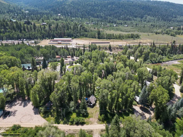 Aerial perspective showcasing a property nestled within a densely wooded landscape