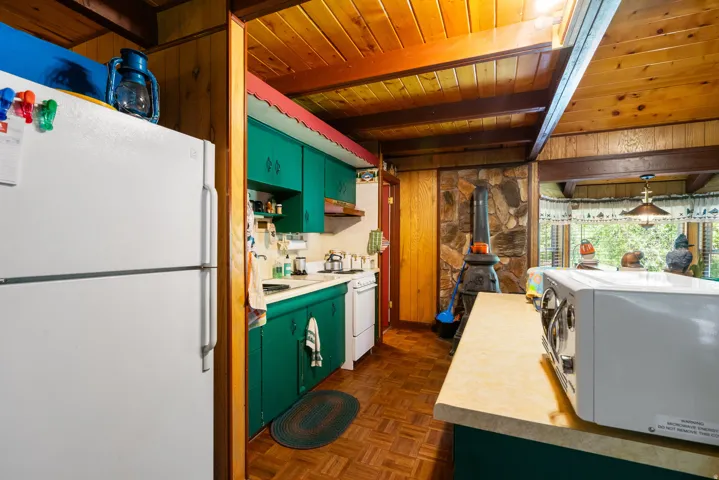 Kitchen with wood-finish flooring and exposed wood beam ceiling
