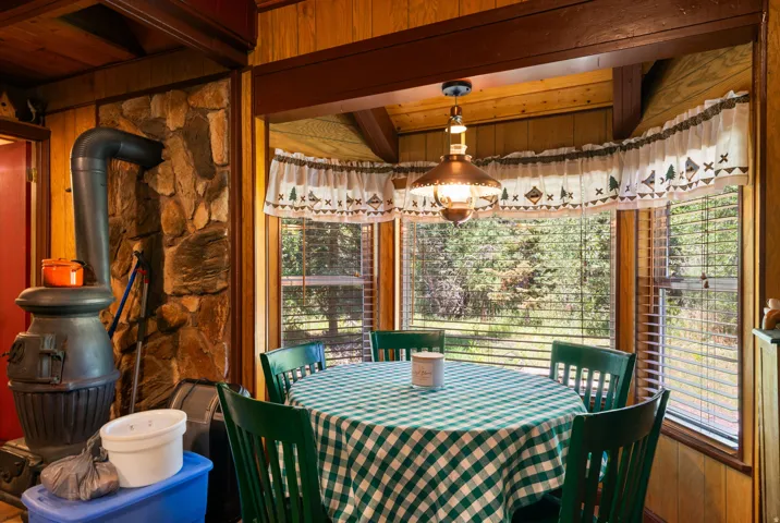 Wood paneling throughout, featuring a natural stone accent wall with a freestanding wood stove