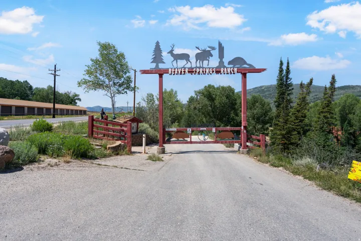 Ranch entrance featuring a decorative metal archway, a gated entry, and natural landscaping