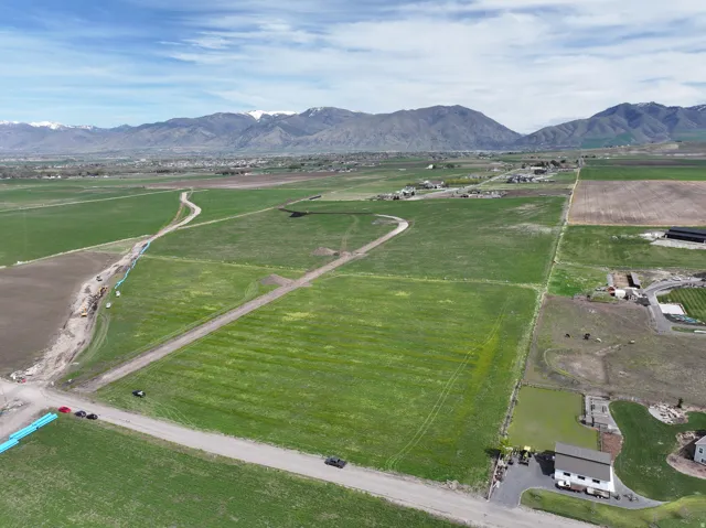 Expansive rural acreage with green fields and distant mountain range