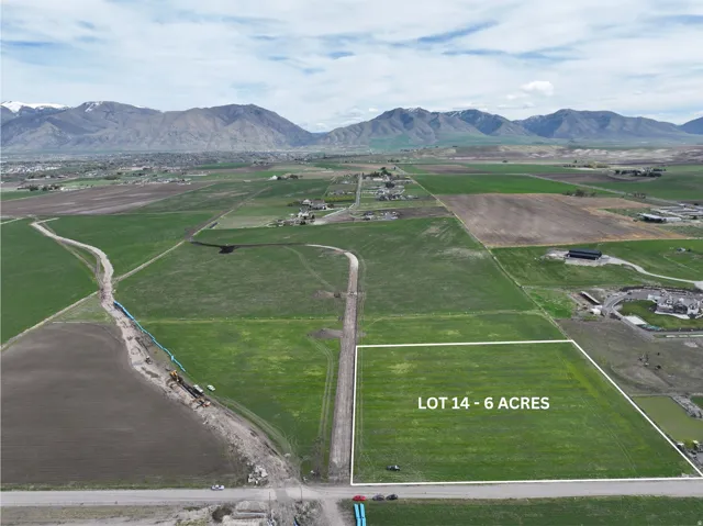 Six-acre parcel with surrounding green fields and mountainous backdrop