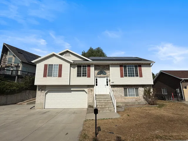 Two-story residence featuring light-colored siding, brick accents, and a front-facing attached garage