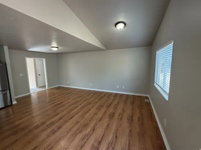 Wood-finish flooring, neutral wall paint, and white trim throughout