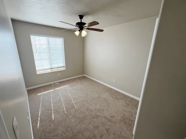 Neutral-toned walls complement the textured carpet flooring
