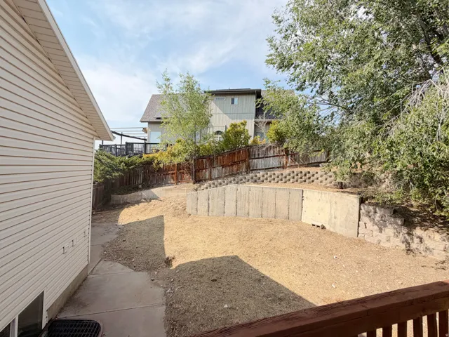 Rear yard with concrete retaining walls and timber fencing