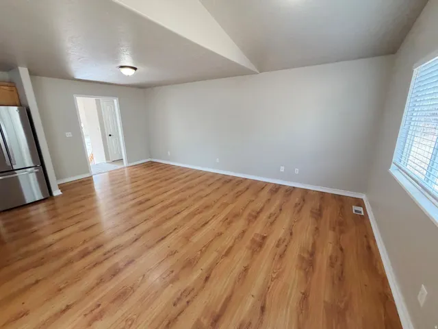 Wood-finish flooring, light gray wall paint, white trim, recessed lighting, and a window with blinds