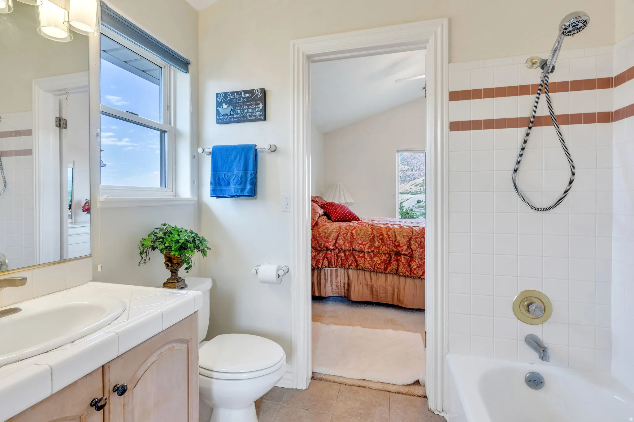 Bathroom with a single vanity, a toilet, and a combination tub and shower