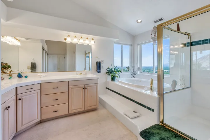 Dual vanity with light wood cabinetry and a large mirror