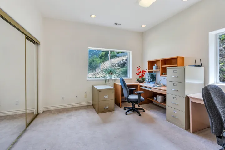 Carpeted room with vaulted ceilings and recessed lighting