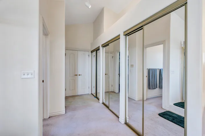 Mirrored closet doors, track lighting, and paneled interior doors