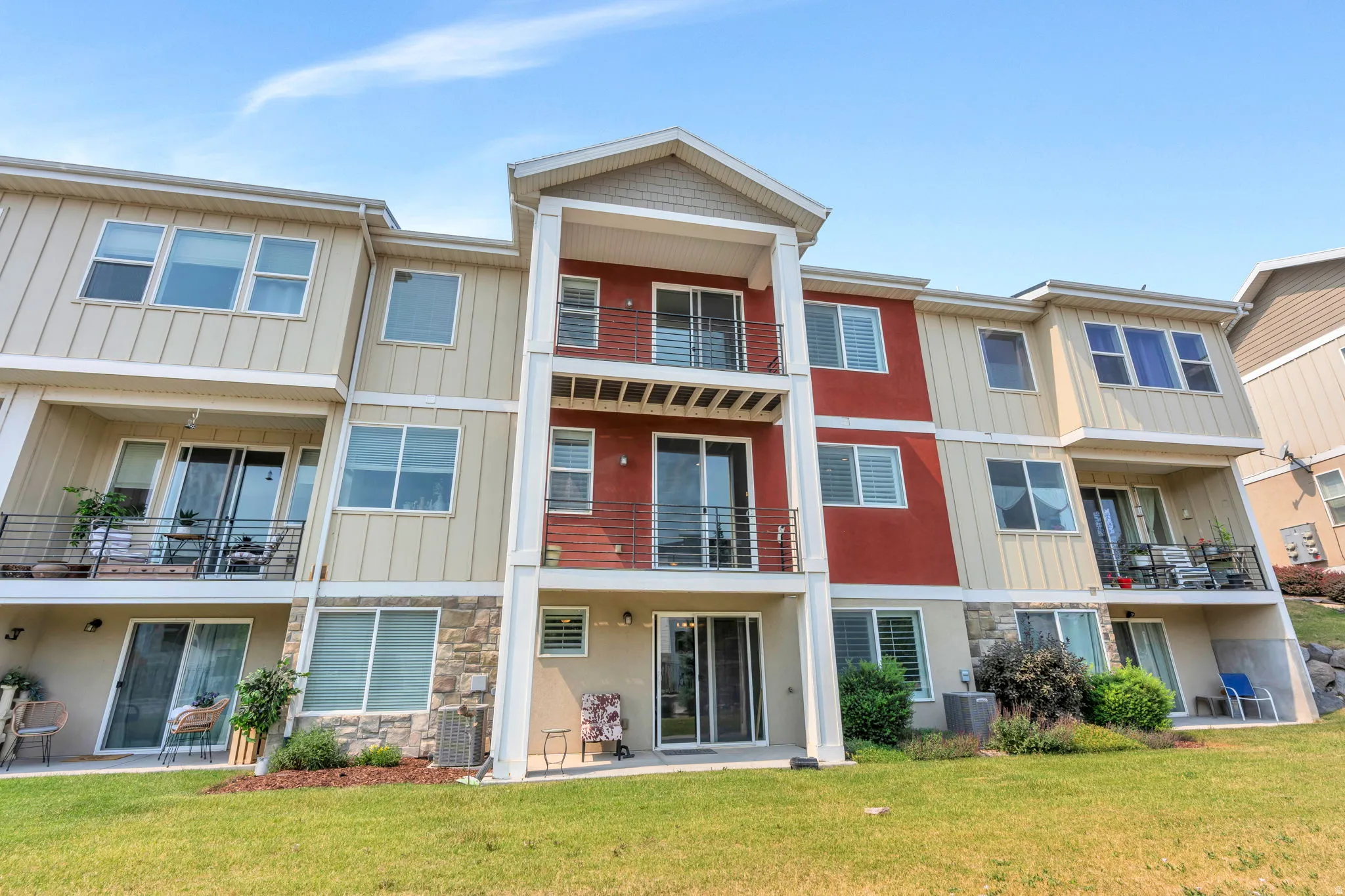 Multi-level condominium complex with a cream, red, and stone facade