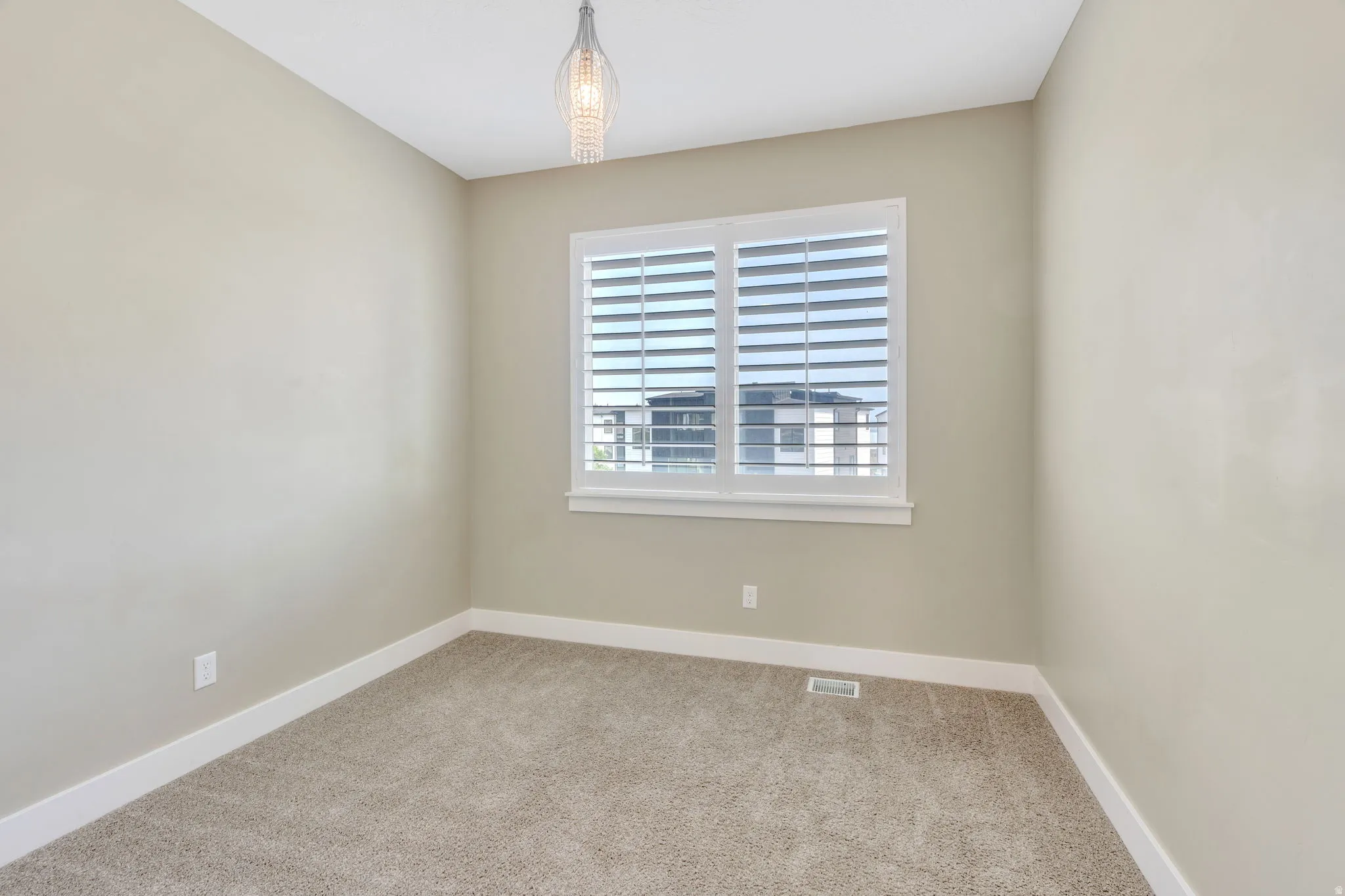 Neutral-toned room with plush carpeting and white baseboards