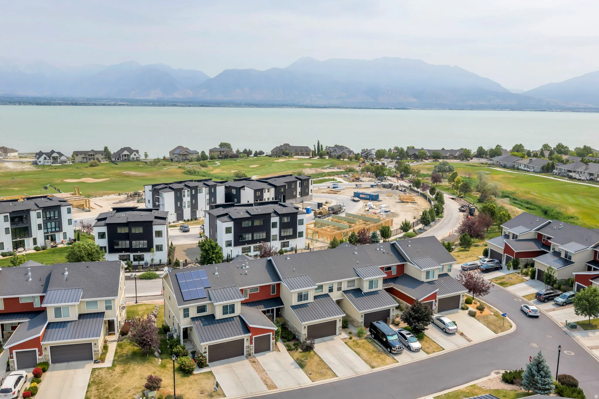 Aerial perspective showcasing a residential development with water and mountain scenery