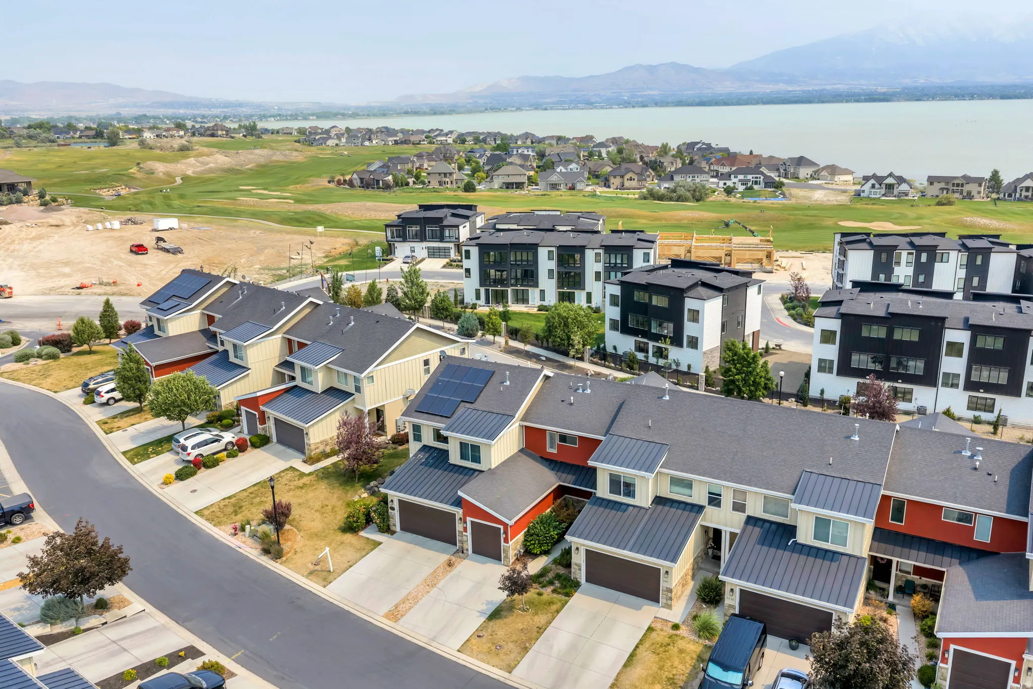 Aerial perspective showcasing a residential community with a lake and mountains in the background