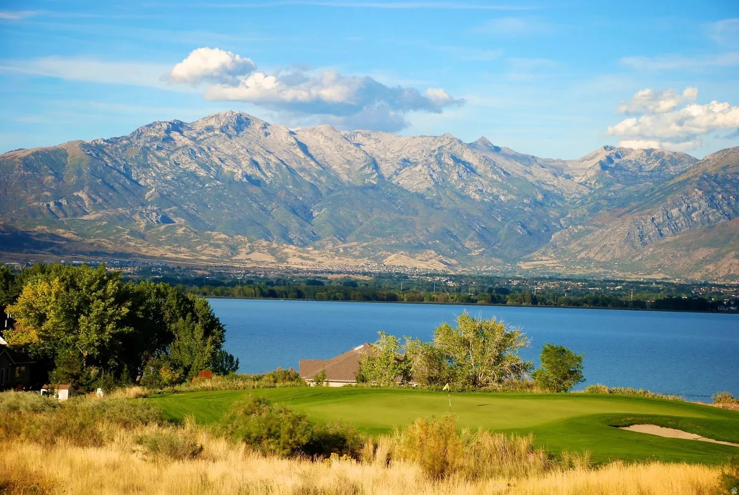 Golf course setting featuring a manicured green and sand trap