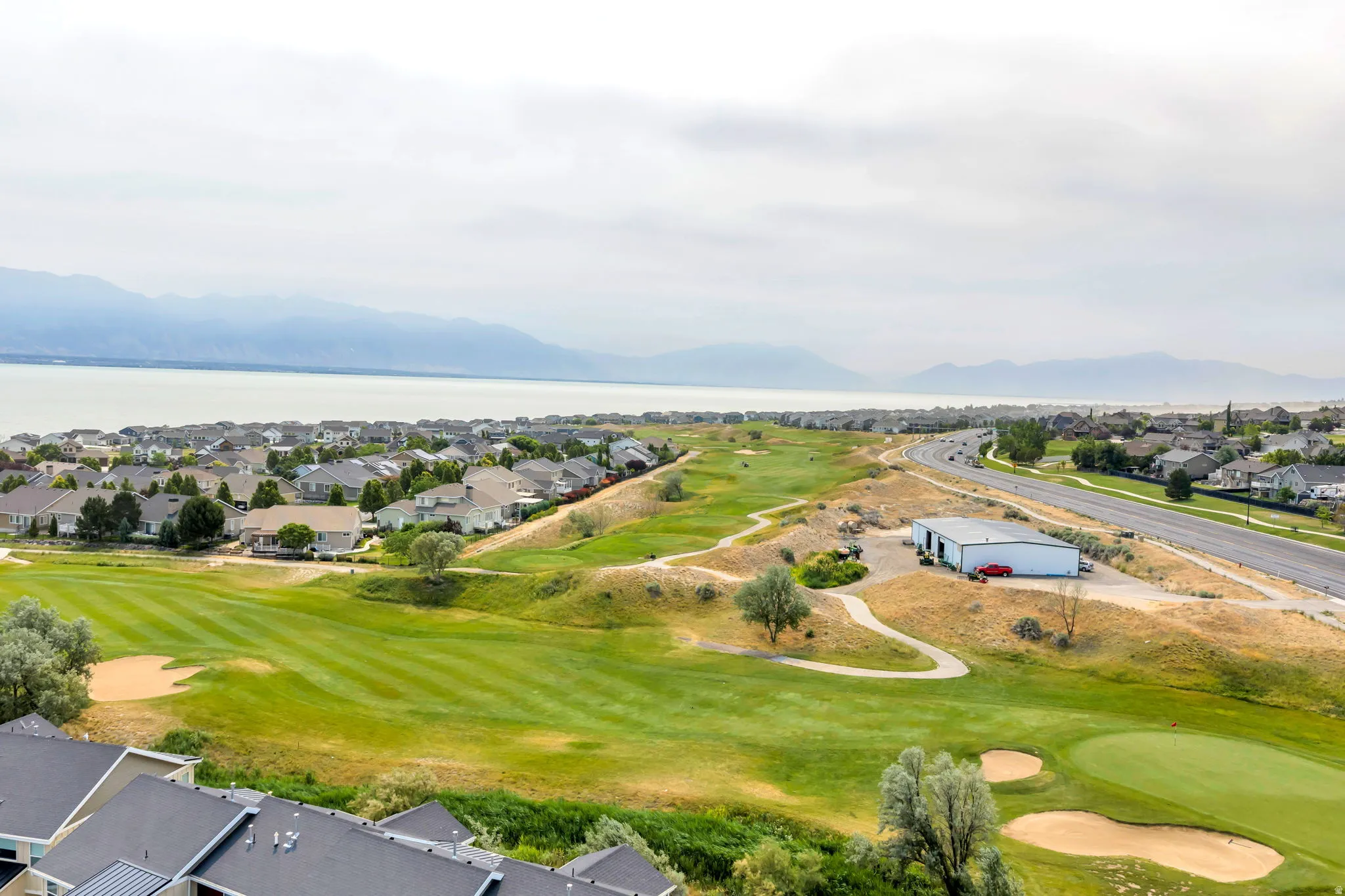 Expansive golf course setting featuring manicured greens and sand traps