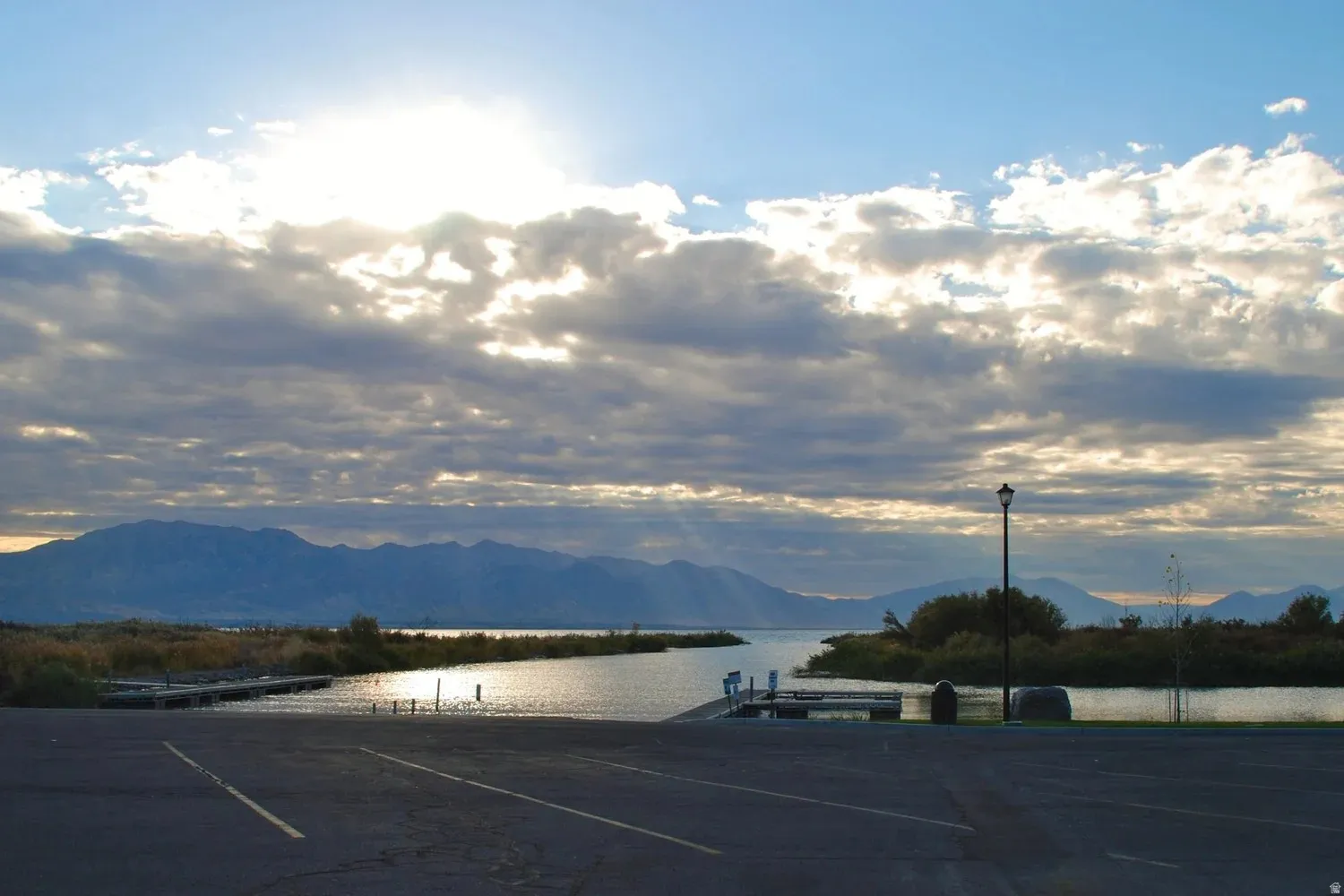 Paved boat ramp extending into a body of water, bordered by two wooden docks