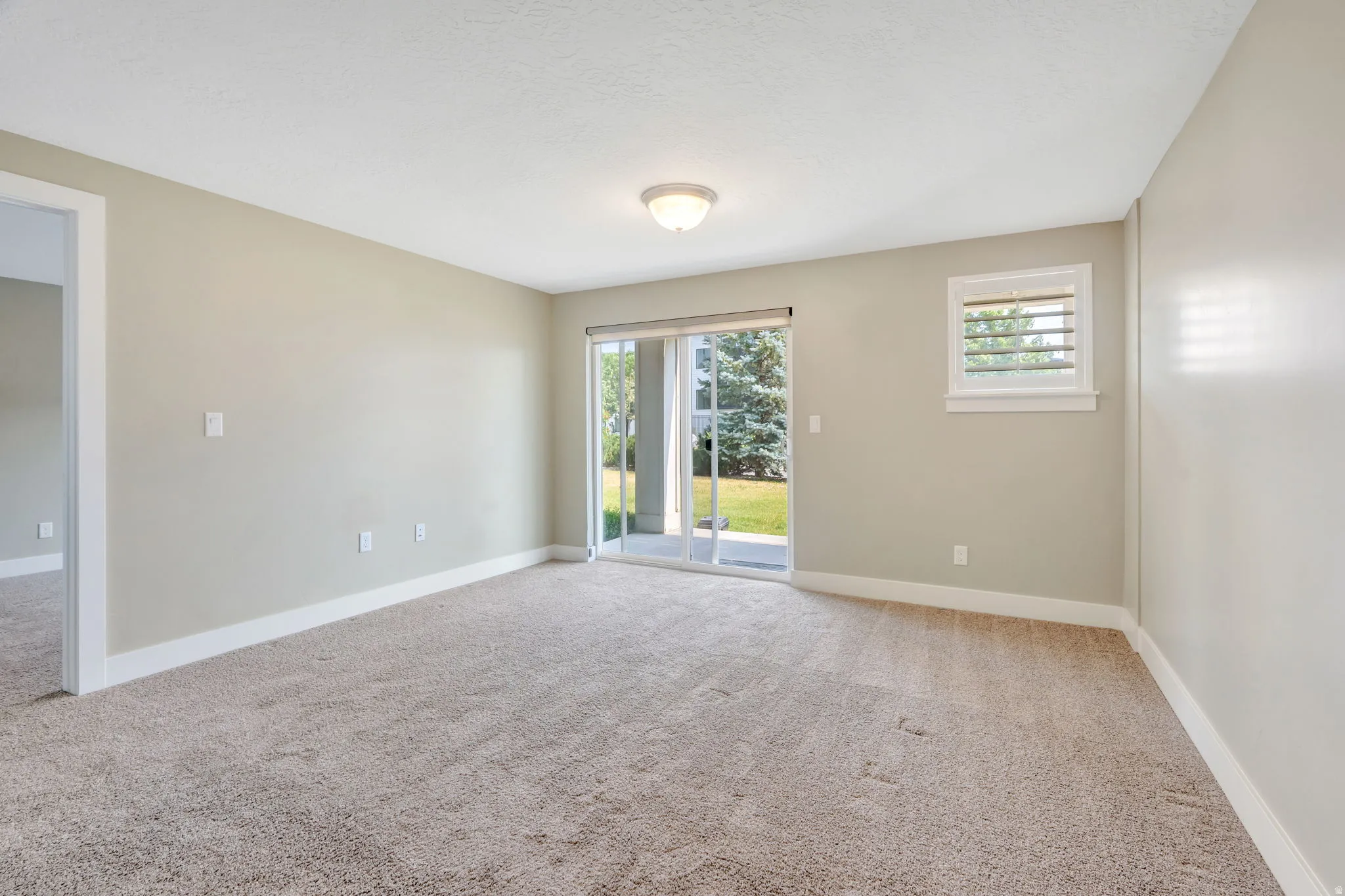 Carpeted interior space with a sliding glass door providing exterior access