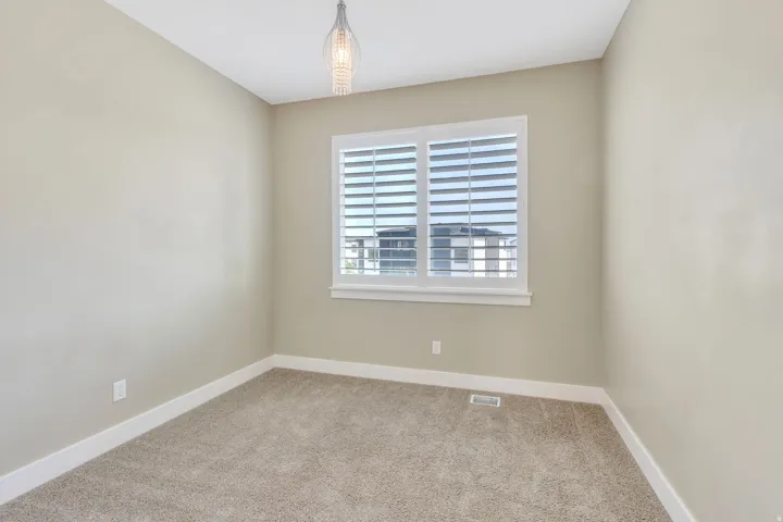Neutral-toned room with plush carpeting and white baseboards