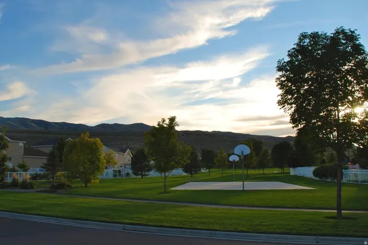 Community green space featuring an asphalt sports court with two basketball hoops