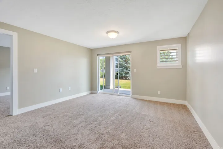 Carpeted interior space with a sliding glass door providing exterior access