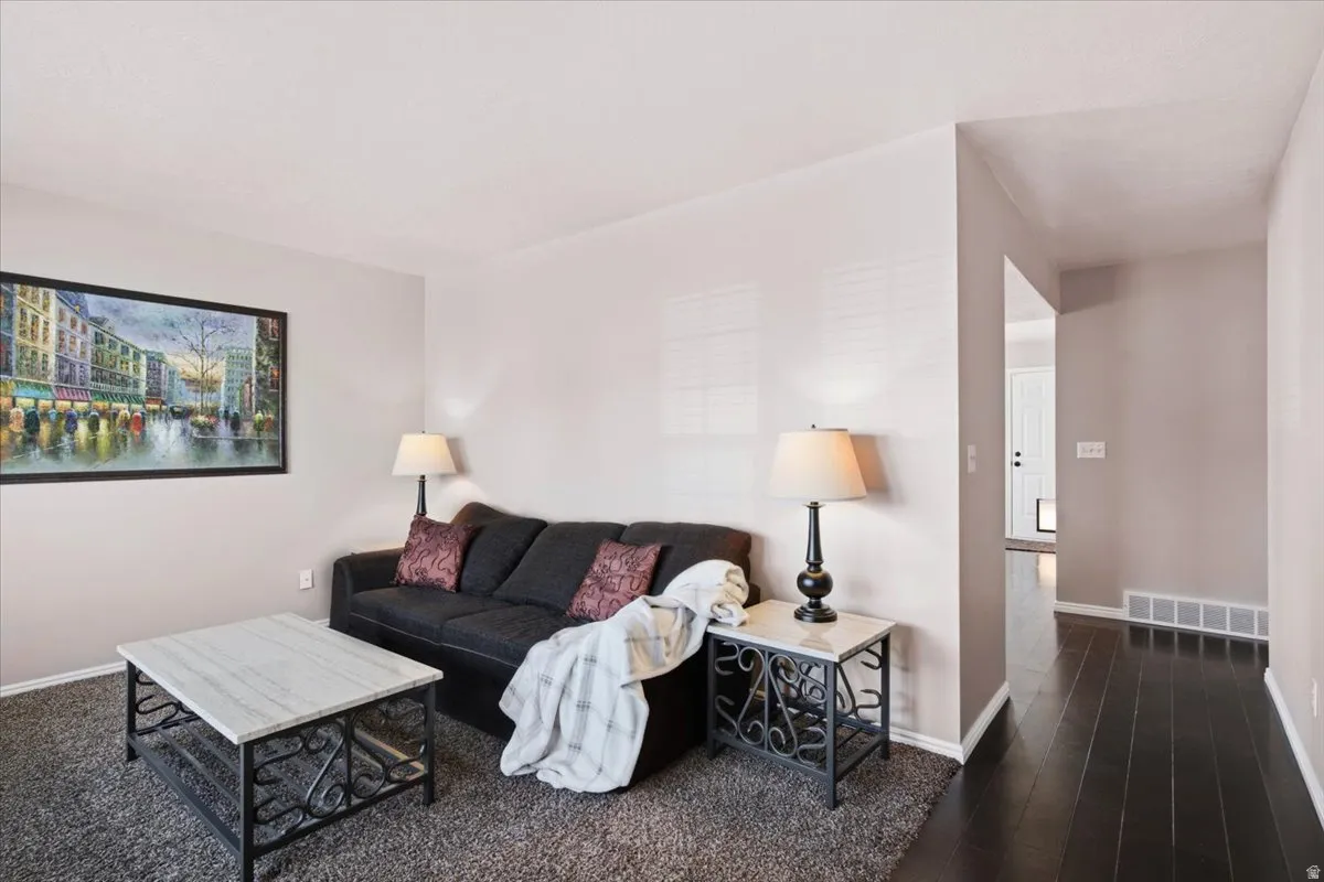 Living area with neutral wall tones and dark wood-finish flooring