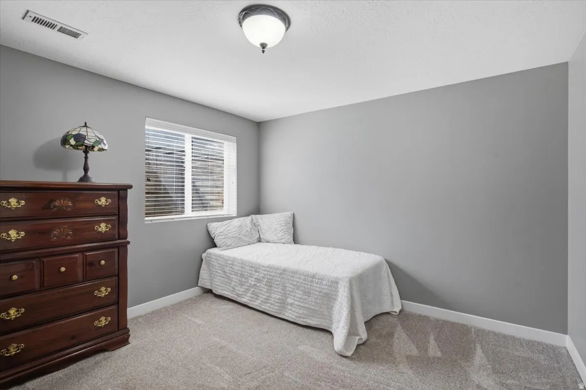Room featuring light gray walls, white trim, and light-colored carpeting