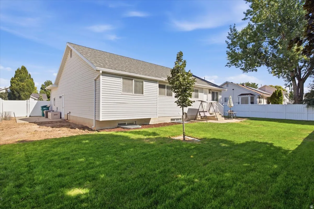Expansive backyard featuring a manicured lawn and mature trees