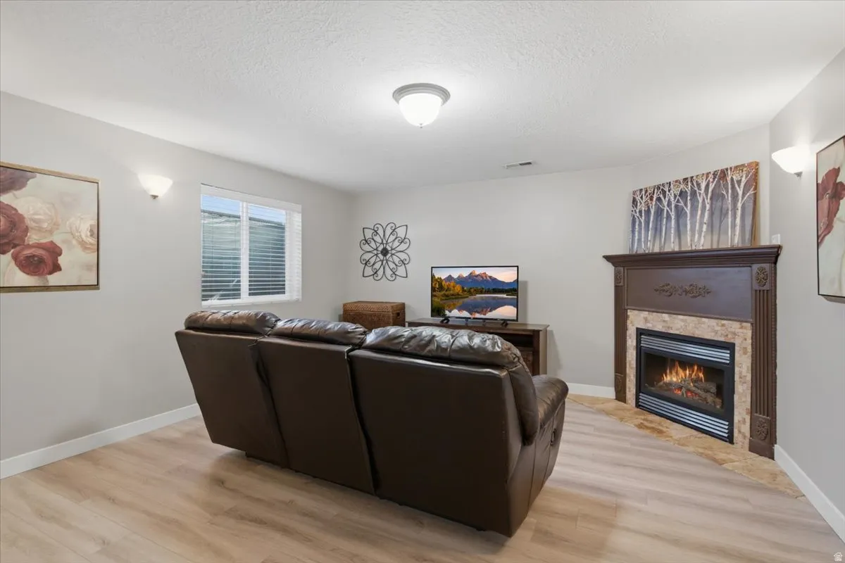 Massive Primary Basement Master with sitting room, Corner fireplace featuring a decorative wood mantel and stone surround