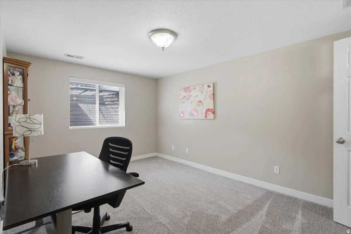 Spacious room featuring neutral carpeting and light-toned walls