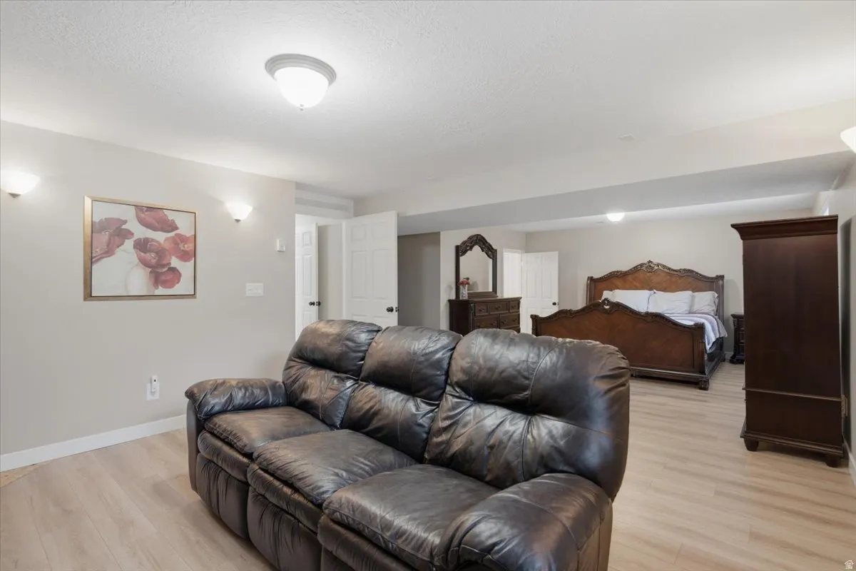 Massive Primary Basement Master room sitting room. Open concept room with light wood-finish flooring