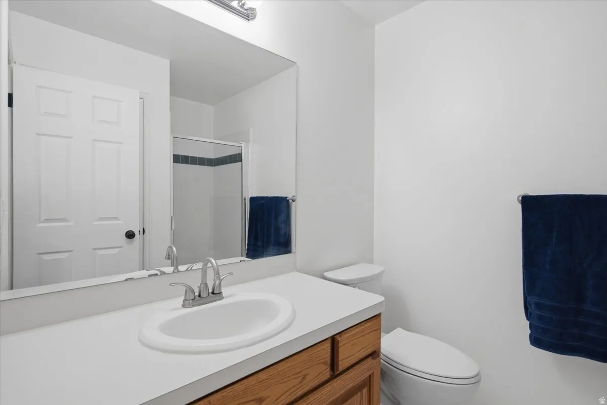 Master Bathroom vanity featuring a white countertop with an integrated sink, wood-finish cabinetry, and a chrome faucet