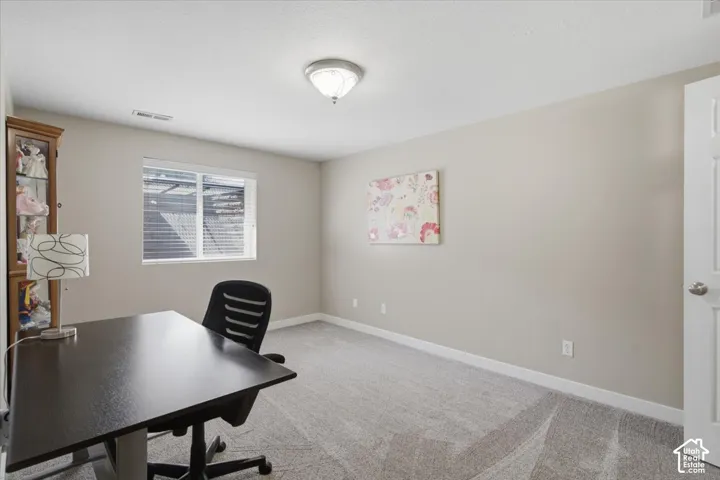 Spacious room featuring neutral carpeting and light-toned walls