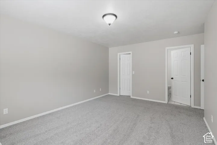 Upstairs 2nd Master, Spacious interior room featuring light brown walls and plush gray carpeting