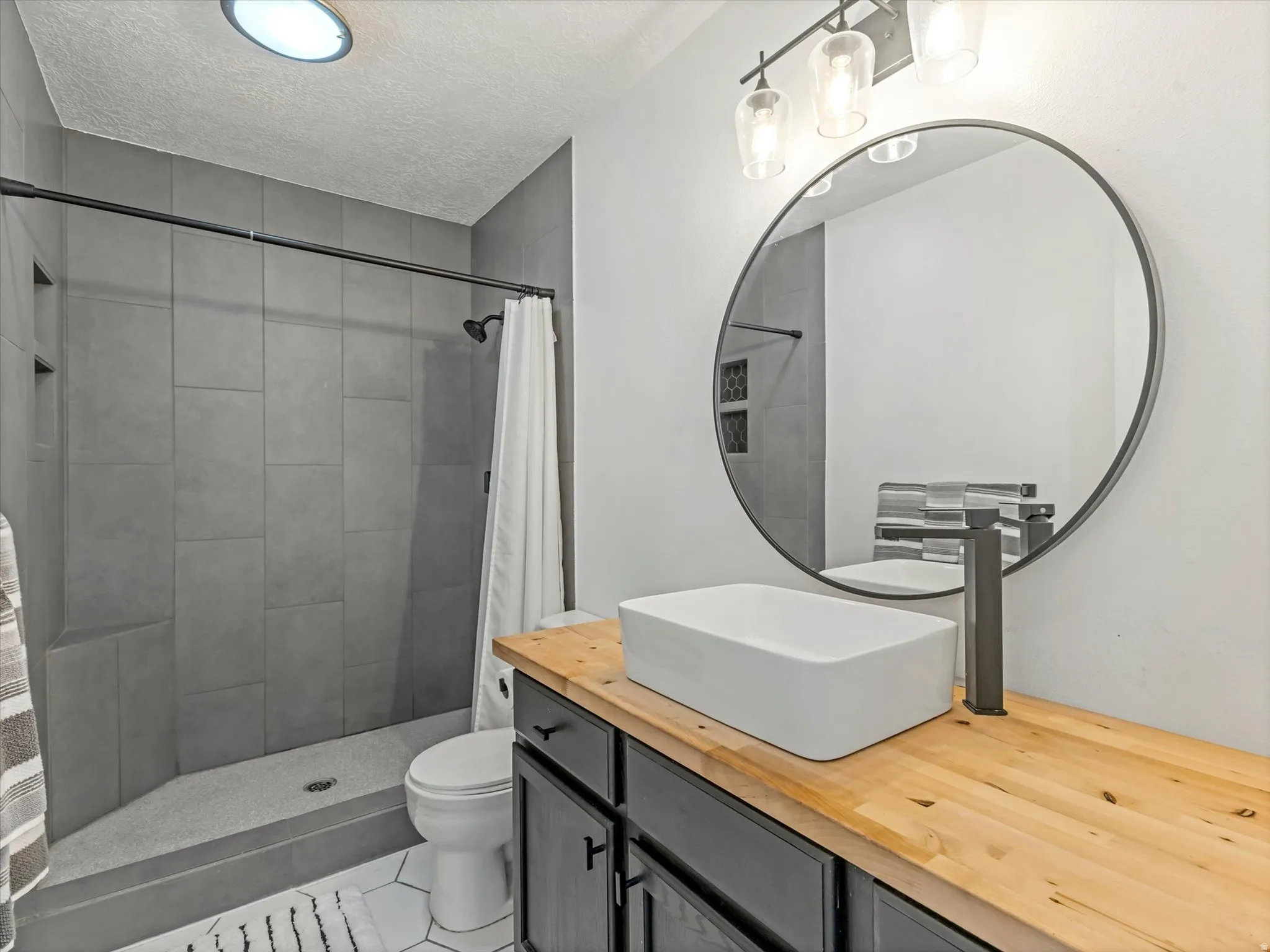 Bathroom featuring a wood-finish vanity countertop with an above-counter rectangular basin and matte black faucet