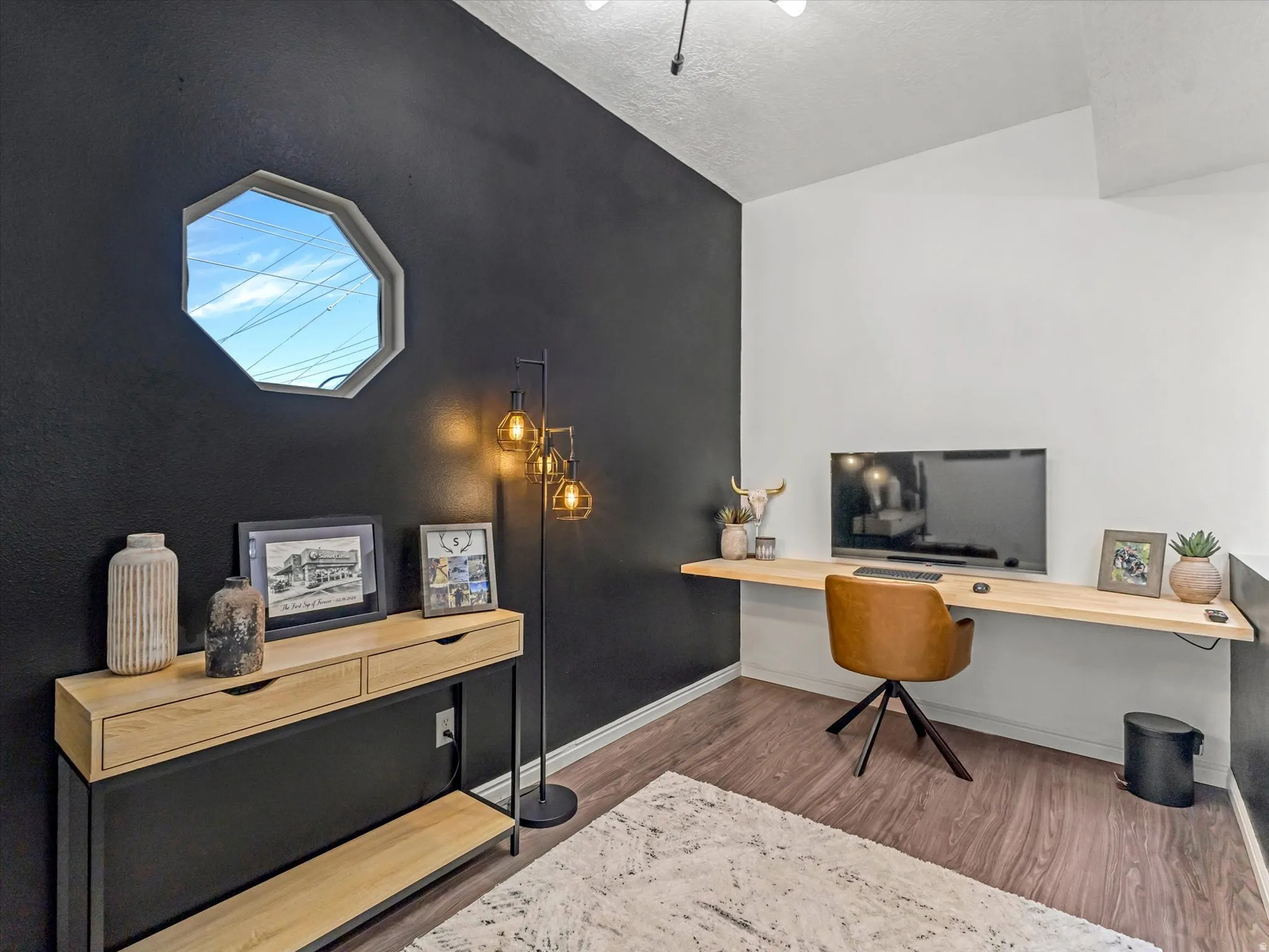 Dedicated workspace featuring a floating wood-finish desk and wood-finish flooring
