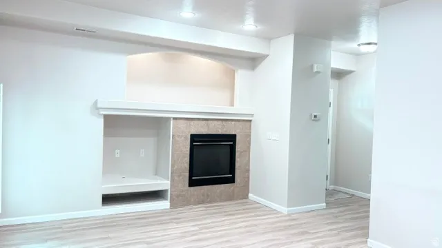 Built-in media center with a recessed fireplace, tiled surround, and integrated shelving