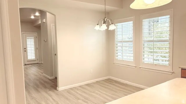 Dining area featuring wood-finish flooring and a contemporary chandelier