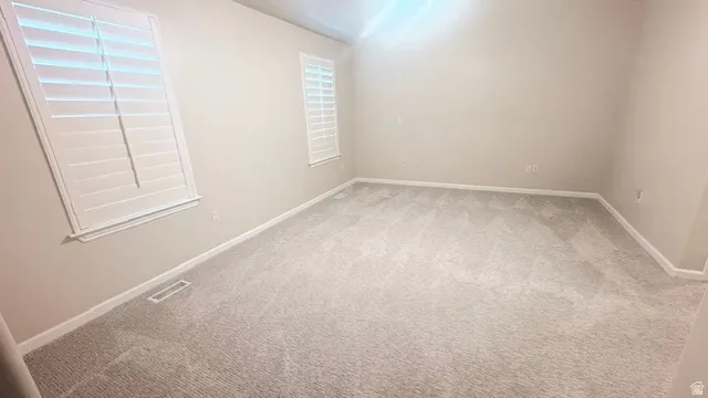 Neutral-toned walls complement the light gray carpeting throughout