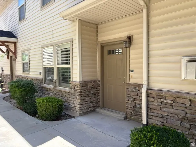 Exterior featuring stacked stone accents, horizontal siding, and a covered entry
