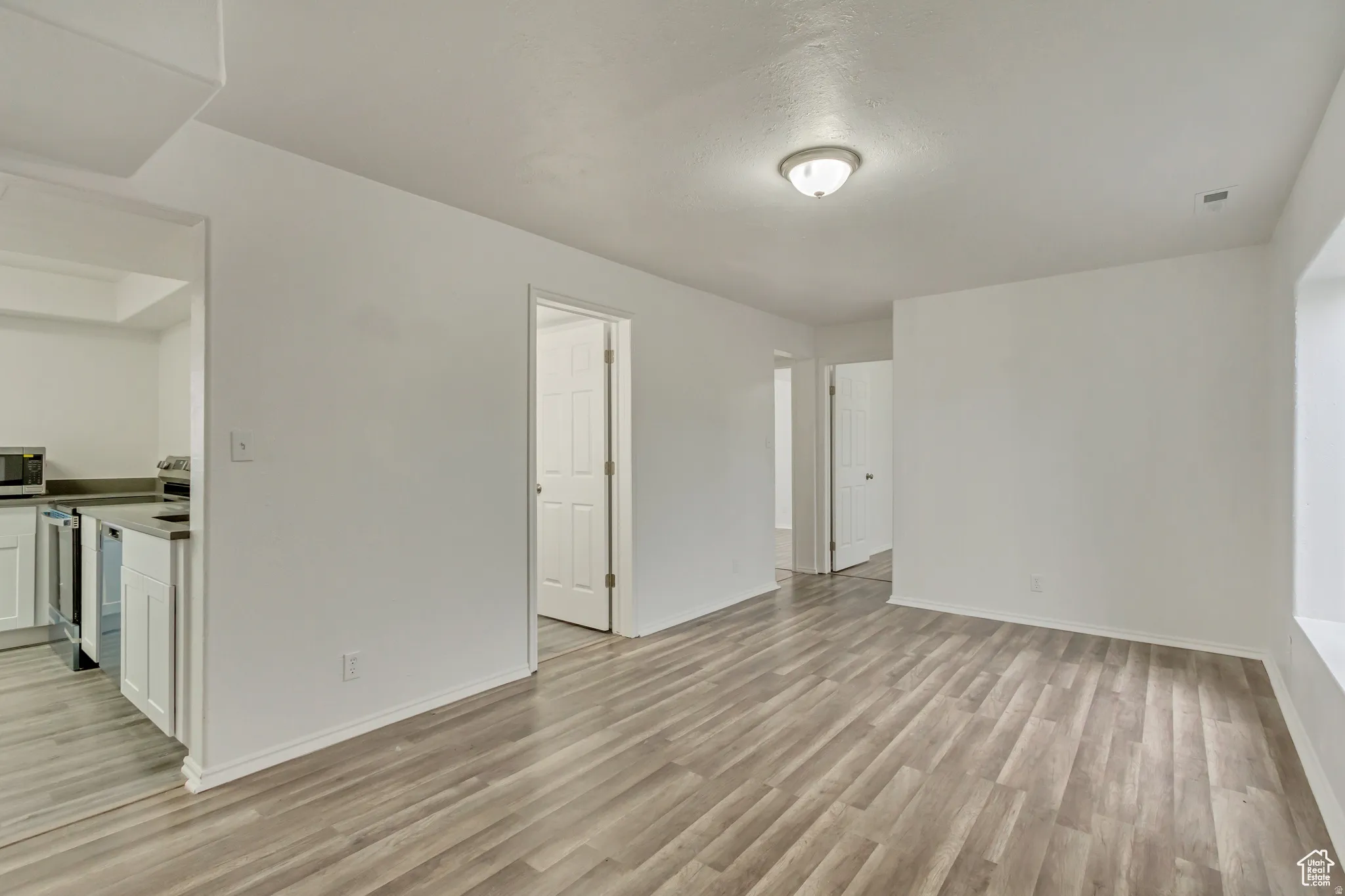 Open concept living area featuring wood-finish flooring and a neutral color palette