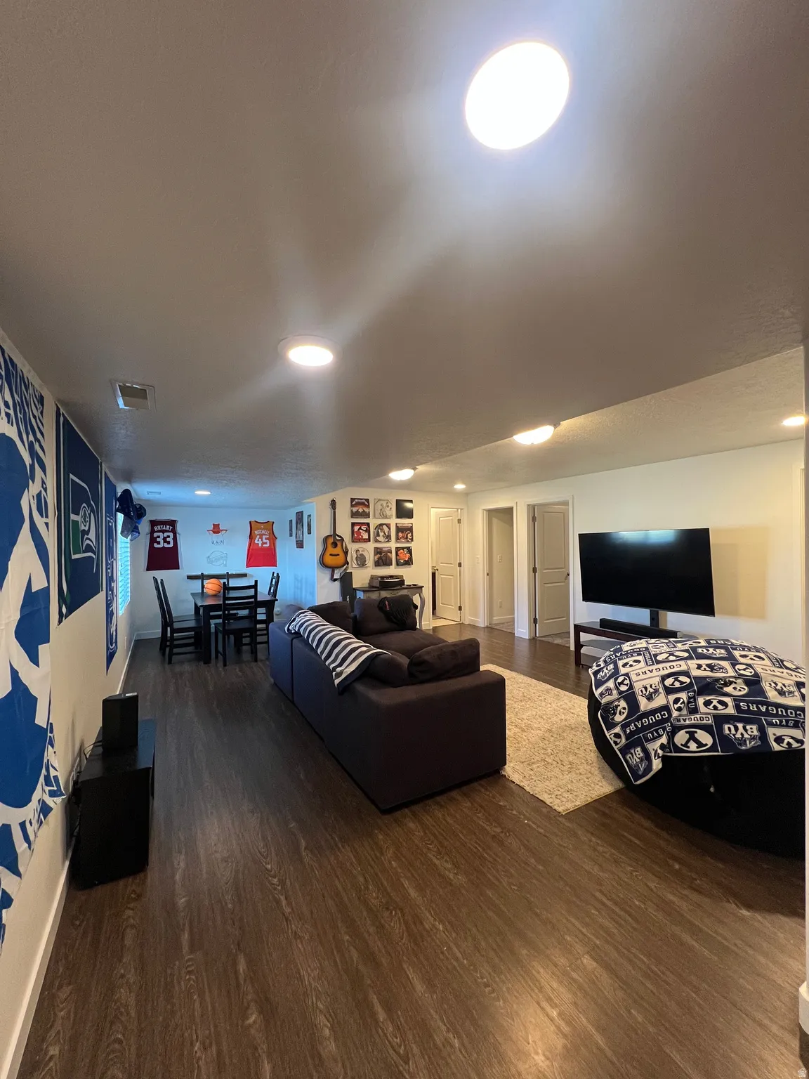 Recessed lighting throughout, wood-finish flooring, and white painted walls