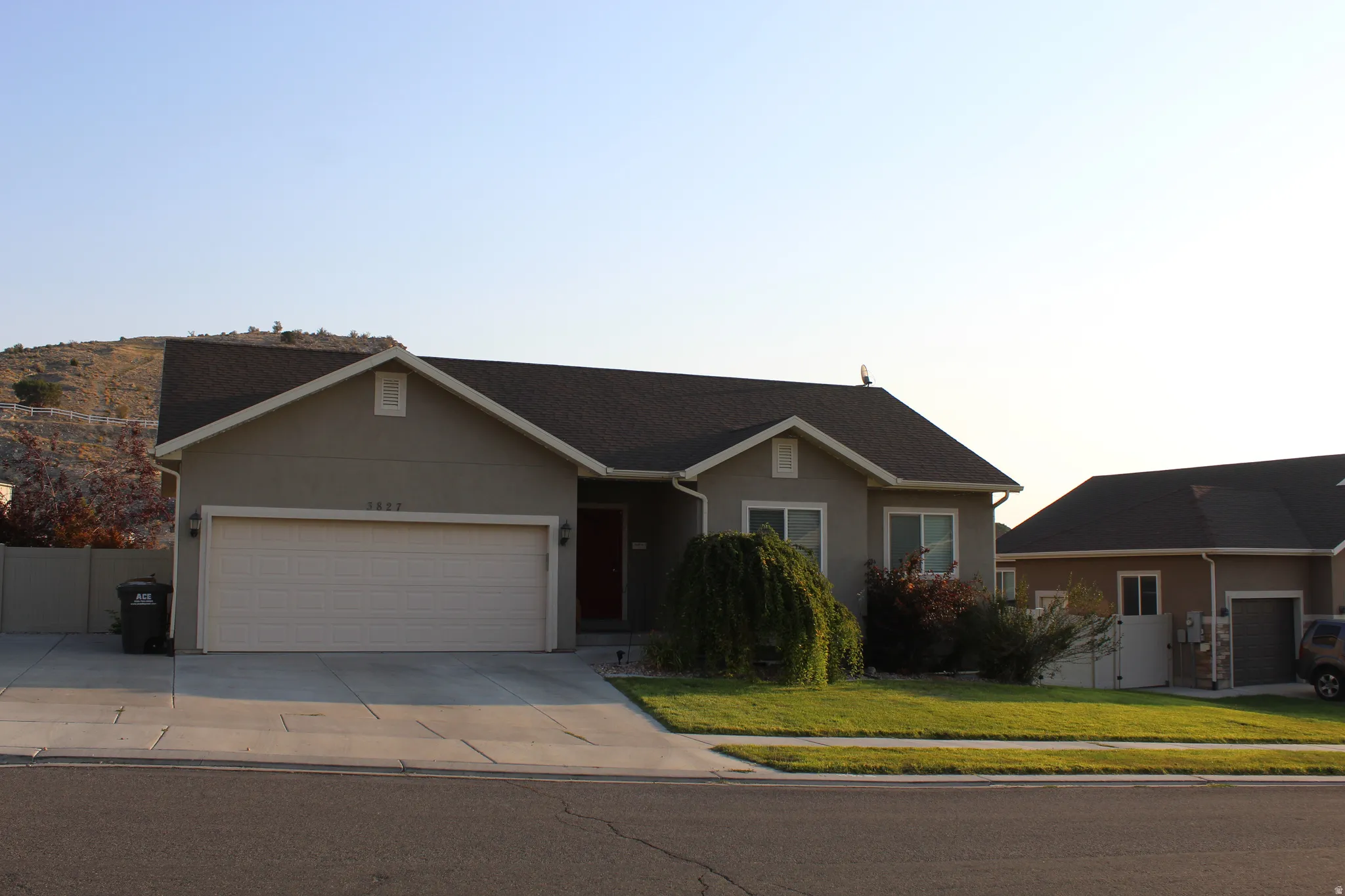 Light gray stucco exterior with a dark shingle roof