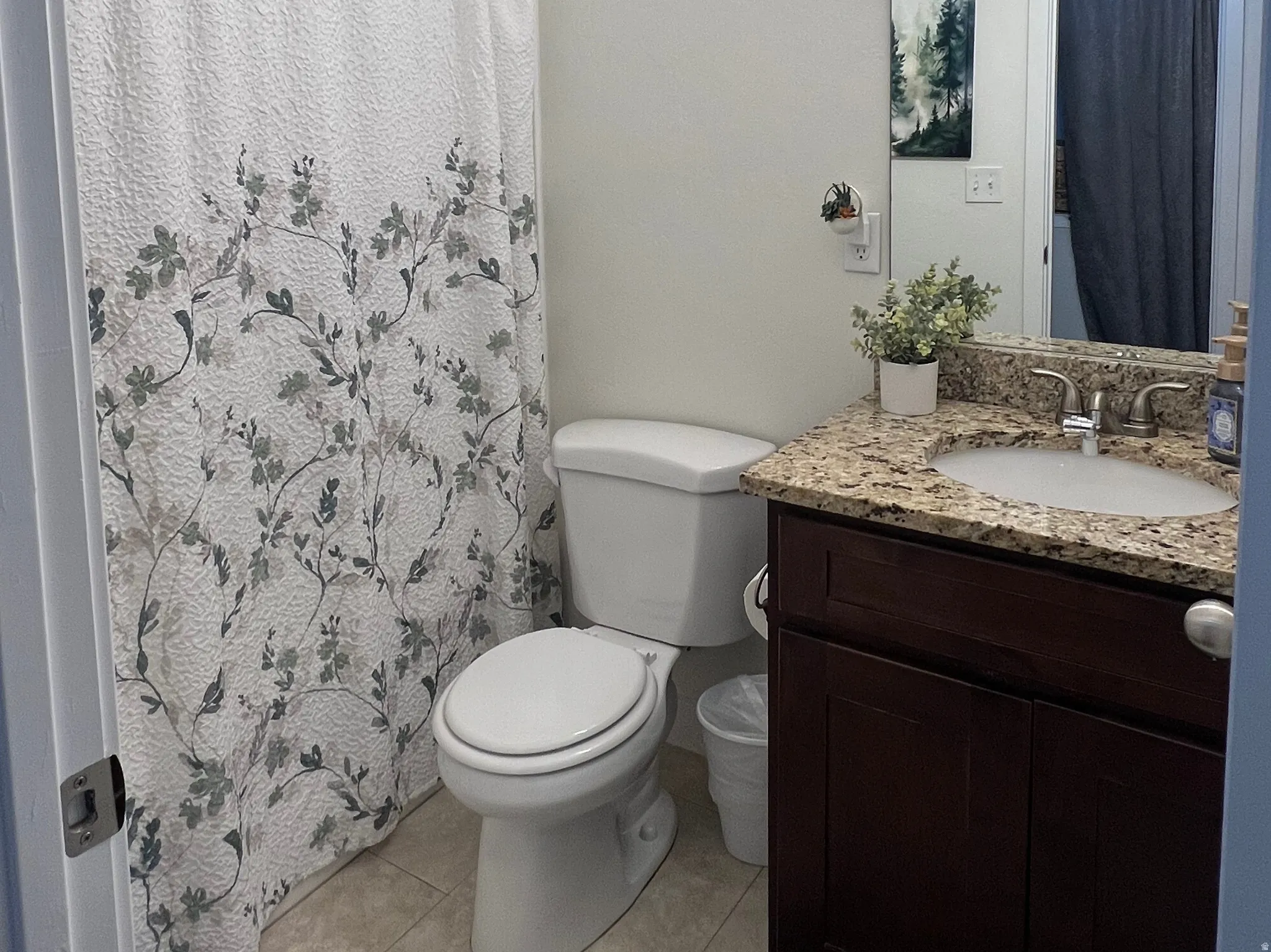 Vanity with granite countertop, integrated sink, and dark wood-finish cabinetry